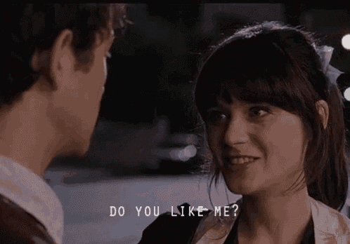 a man and a woman are looking at each other and the woman is smiling while the man says `` do you like me '' .