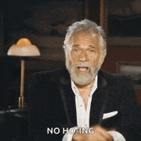 a man in a suit and tie is pointing at the camera and saying `` no ho ing '' .