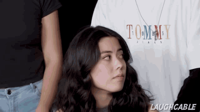 a woman wearing a white tommy jeans shirt