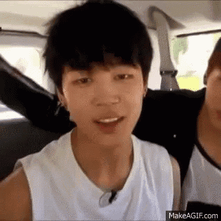 a young man is sitting in the back seat of a car with another young man .