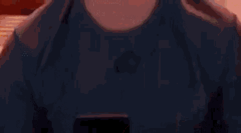 a man is standing in a bedroom looking at his cell phone .