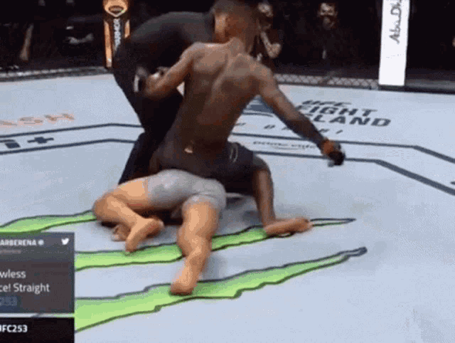 two men are wrestling in a ring with a monster energy logo on the ground
