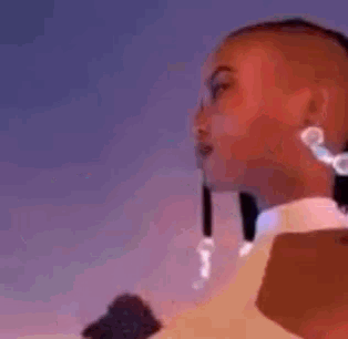 a close up of a woman wearing earrings and a collared shirt .