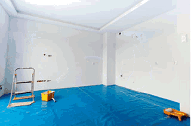 an empty room with blue plastic on the floor and a ladder
