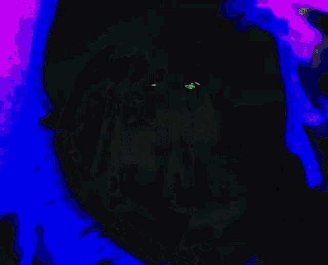 a dark room with a green light and a green smoke coming out of the corner