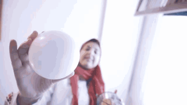a woman is holding a white ball in her hand