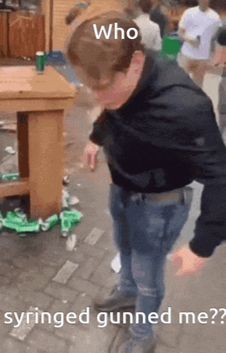 a man is standing in front of a table with the words who syringe gunned me