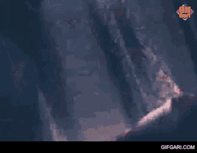 a close up of a person 's face with a blurred background and the words gifgari.com on the bottom .