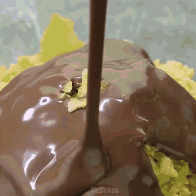 melted chocolate is being poured on a piece of food with the words mccakes written on the bottom
