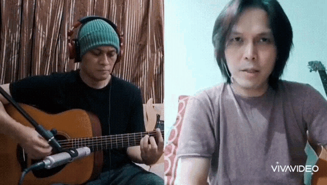 a man wearing headphones is playing a guitar next to another man wearing a purple shirt