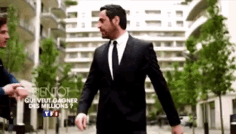 a man in a suit shakes hands with another man