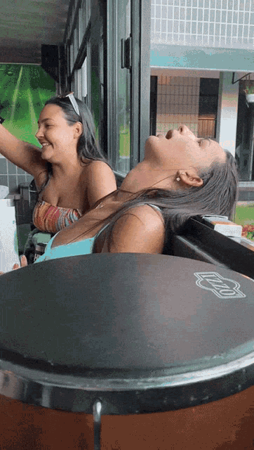 a woman in a bikini is laying on a table with a drum that says ' zildjian ' on it