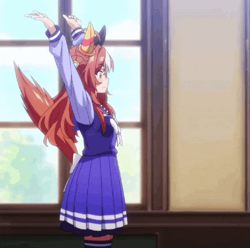 a girl in a blue dress is standing in front of a window with her arms up