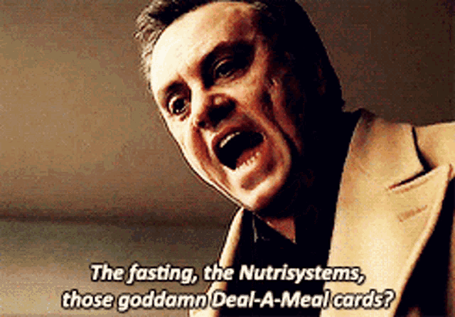 a man in a suit says the fasting the nutrisystems those goddamn deal-a-meal-cards