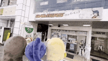 a group of stuffed animals are standing in front of a building that says gamers