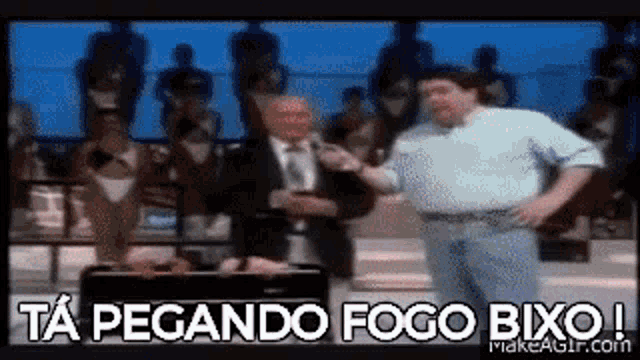 a man is standing next to another man with the words ta pegando fogo bixo written on the bottom