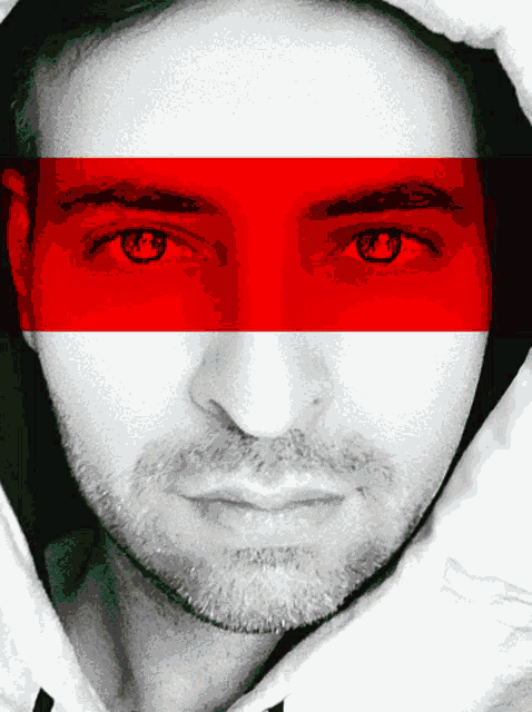 a close up of a man 's face with a red white and black stripe on his eyes