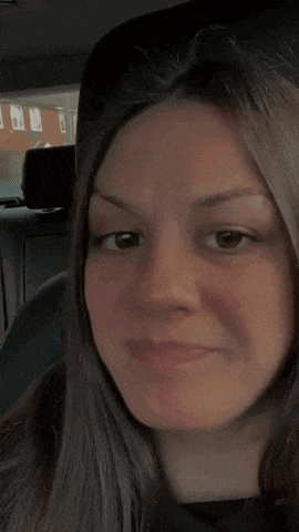 a woman is sitting in the back seat of a car and making a funny face