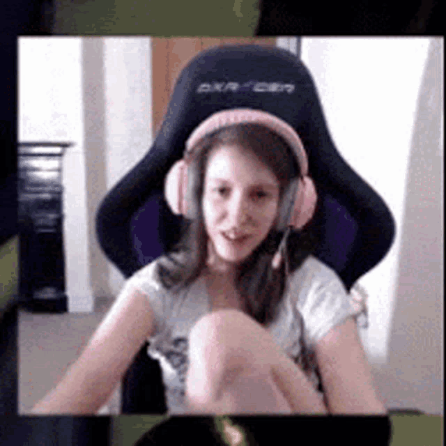a young girl wearing headphones is sitting in a chair .