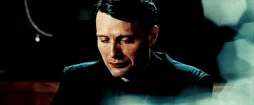 a close up of a man 's face in a dark room with a blurred background .