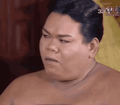 a shirtless man is making a funny face and looking at the camera .