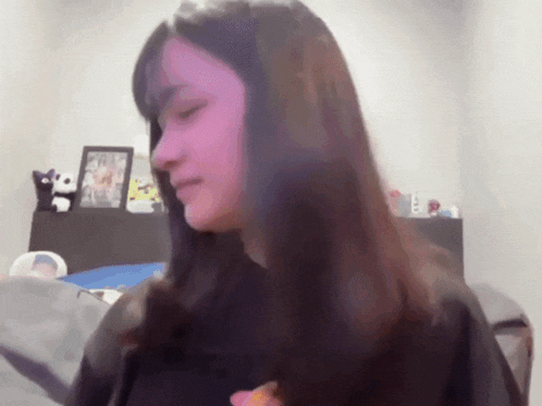 a woman is standing in front of a shelf with a picture on it
