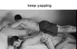 two men are laying on top of each other on a bed and one of them is holding the other 's butt .