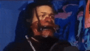 a man with dreadlocks is wearing a mask and headphones while playing a video game .