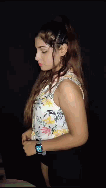 a woman in a floral top and black shorts is dancing