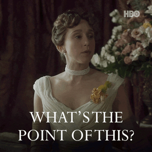 a woman in a white dress says " what 's the point of this " in front of flowers