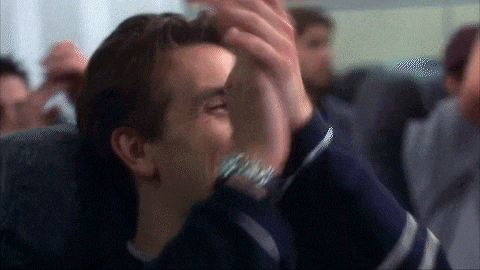 a man is sitting on an airplane with his hands on his face .