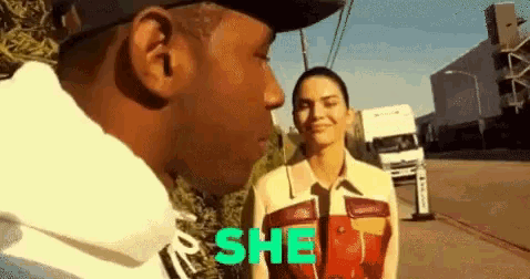 a man and a woman are standing next to each other on the side of a street .