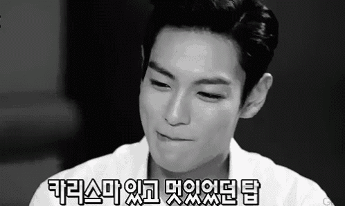 a black and white photo of a young man making a funny face with korean writing .