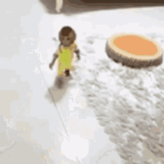 a small monkey in a yellow outfit is walking on a marble floor .