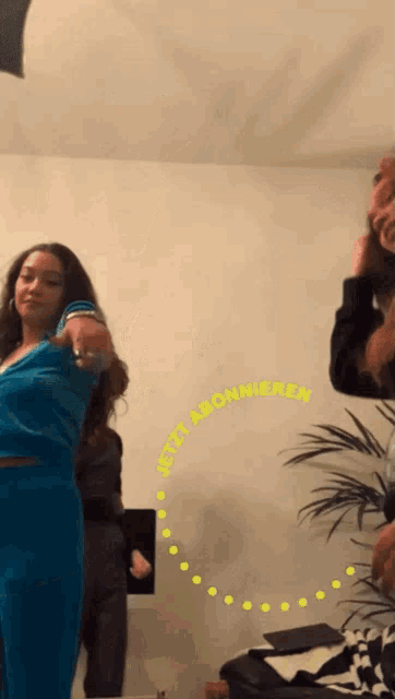 a woman in a blue outfit is dancing in front of a sign that says " mit abonneren "