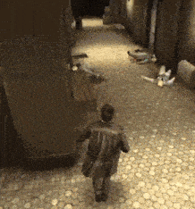 a man in a leather jacket is walking down a narrow alleyway