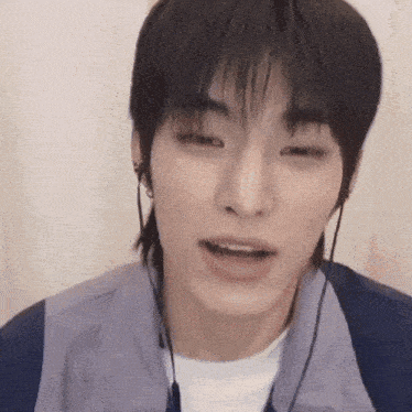 a close up of a young man wearing headphones and a mullet .
