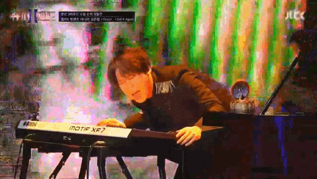 a man is playing a motif xf7 keyboard on a stage