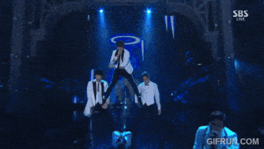 a man in a suit is dancing on a stage in front of a sbs live logo