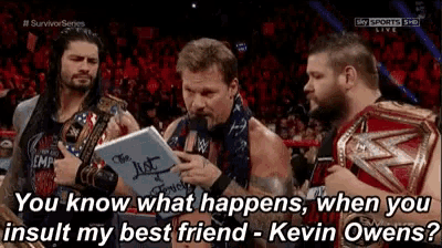 a group of wrestlers are standing in a ring and one of them is holding a piece of paper that says kevin