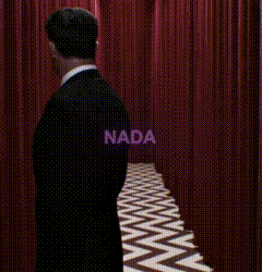a man in a suit is walking down a hallway with red curtains and a chevron floor .