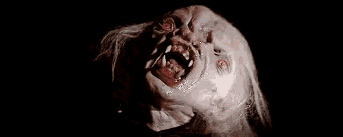 a close up of a monster with red eyes and sharp teeth .