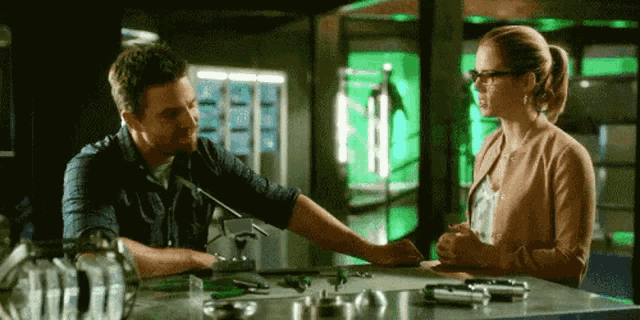 a man and a woman are sitting at a table looking at something