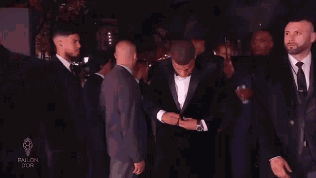 a man in a tuxedo holding an umbrella with the words kylian mbappe forward paris-sg