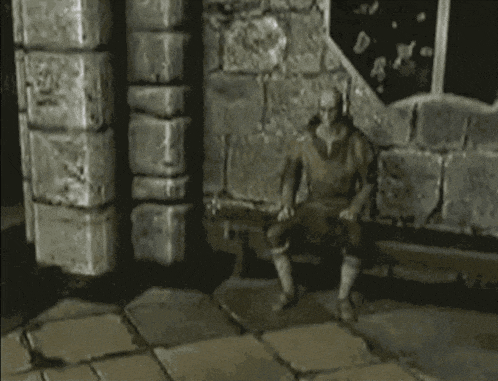 a statue of a man is sitting on a bench in front of a stone wall