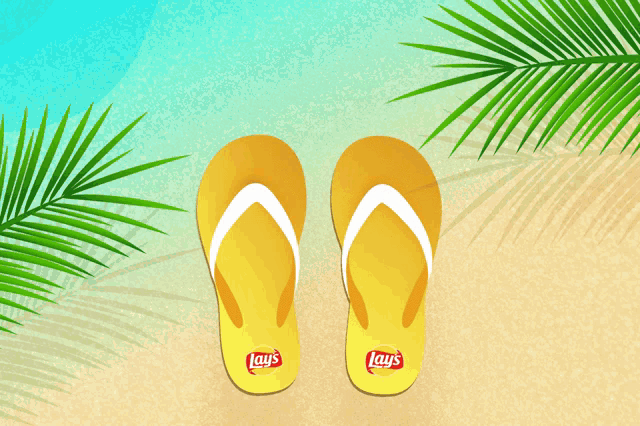 a pair of yellow lays flip flops on a sandy beach