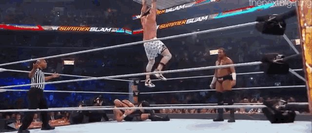 a wrestler is jumping over another wrestler in a ring that says summerslam