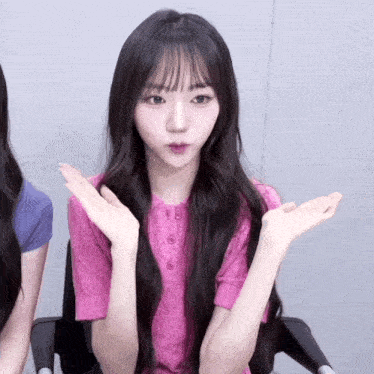 a girl in a pink shirt with her hands outstretched