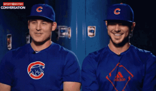 two chicago cubs baseball players are smiling in front of a locker
