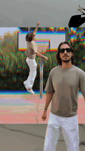 a man wearing sunglasses is standing in front of a basketball hoop while another man jumps in the air